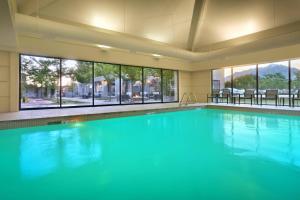 - une piscine d'eau bleue dans une chambre avec fenêtres dans l'établissement Courtyard by Marriott Salt Lake City Sandy, à Sandy