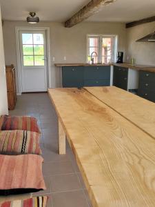 een grote keuken met een houten tafel in het midden bij Atma Guesthouse - cozy and simple bed & breakfast in the countryside in Marstal