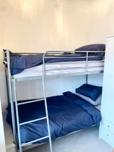 two bunk beds in a room with blue pillows at Remarkable 2-Bed Apartment in Torquay in Torquay