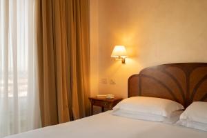 ein Hotelzimmer mit einem Bett und einem Fenster in der Unterkunft Grand Hotel Astoria in Grado