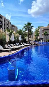 a swimming pool with chairs and umbrellas in a resort at Wonderful Deluxe Appartement in Cascadas Family Resort in Sunny Beach