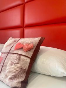 Una almohada con corazones sentada en una cama en Hotel Olympia, en Arabba