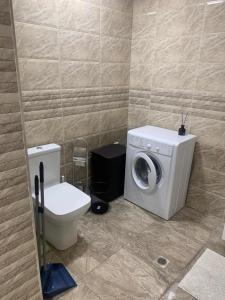a bathroom with a washing machine and a toilet at Orbeli Karine in Yerevan