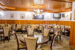 a dining room with tables and chairs and a television at Hotel Apollon in Metsovo