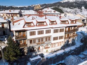 un grand bâtiment avec de la neige au-dessus dans l'établissement Hotel Apollon, à Metsovo