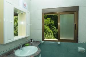 a bathroom with a sink and a window at Apartamentos rurales La Veiga in La Riera