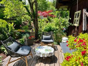 a patio with three chairs and a table and flowers at Alte Mühle Appartements in Seefeld in Tirol