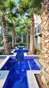a swimming pool with palm trees in a resort at Wonderful Deluxe Appartement in Cascadas Family Resort in Sunny Beach