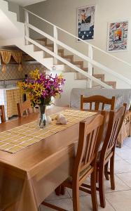 a dining room table with a vase of flowers on it at Villetta Giada in San Pietro in Bevagna