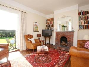 a living room with a fireplace and a tv at The Highlands - Nr Rye - Tennis Court in Iden