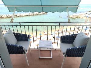 een balkon met 2 stoelen en uitzicht op het strand bij G&G Holidays in Santa Maria di Castellabate