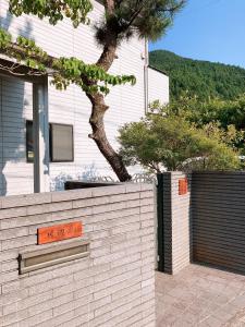 a white brick wall with an orange sign in front of a house at 川辺-KAWABE-BBQ-川遊び-fishing in Hanno