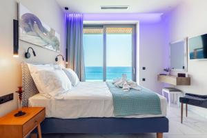 a bedroom with a large bed and a large window at Rocca al Mare Seaside Villas in Palaiokastro
