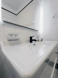 a white bathroom with a sink and a mirror at Sarah's Apartment - Playa Fañabe in Adeje