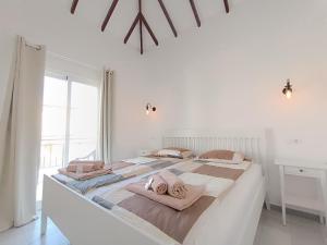 a white bedroom with a large bed with towels on it at Sarah's Apartment - Playa Fañabe in Adeje