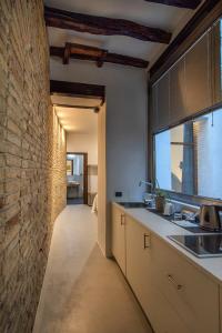 a kitchen with a large window and a brick wall at C&O Savoia Deluxe Rooms in Cagliari +105 photos