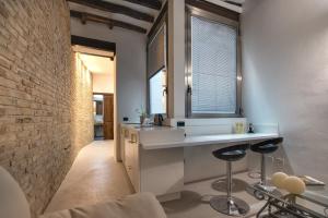 a bathroom with a sink and a brick wall at C&O Savoia Deluxe Rooms in Cagliari