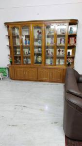a wooden cabinet in a living room with a couch at Ohm Shanthi Homestay in Pondicherry