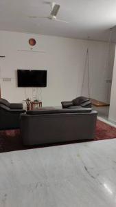 a living room with a couch and a flat screen tv at Ohm Shanthi Homestay in Pondicherry