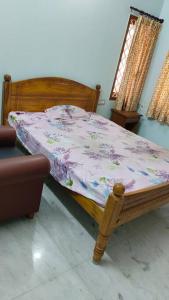 1 dormitorio con cama de madera y ventana en Ohm Shanthi Homestay en Pondicherry