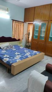 a bedroom with a bed with a blue comforter at Ohm Shanthi Homestay in Pondicherry