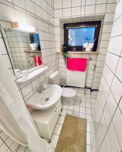 Baño blanco con lavabo y aseo en Moderne Wohnung in Vorstadtidylle zu Bayreuth, en Heinersreuth