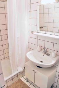 Baño blanco con lavabo y espejo en Moderne Wohnung in Vorstadtidylle zu Bayreuth, en Heinersreuth