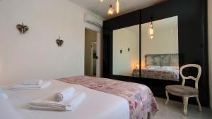 a bedroom with a bed and a chair and a mirror at Sweetheart Apartment in Busto Arsizio