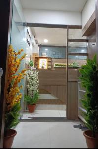 een kamer met potplanten op de vloer en een keuken bij Hotel Royal Sky in Ahmedabad