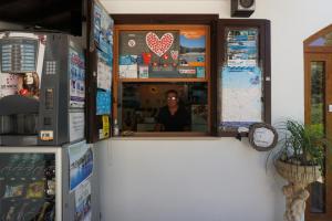 un hombre sentado en una ventana en una tienda en Residence Valleverde, en Vieste