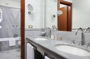 a bathroom with two sinks and a shower at Hotel Mecenate Palace in Rome