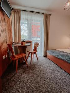 扎科帕內的住宿－Stan Relaksu - noclegi w Zakopanem，一间卧室配有桌子、椅子和一张床