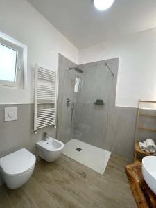 a bathroom with a shower and a toilet and a sink at Le Fronde Vieste in Vieste