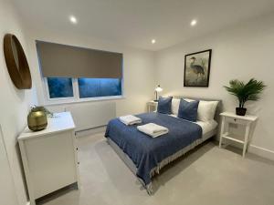 a bedroom with a blue bed and a window at Addlestone Exquisite 6 double bedrooms and 3 Bathroom Detatched House 9 in Addlestone