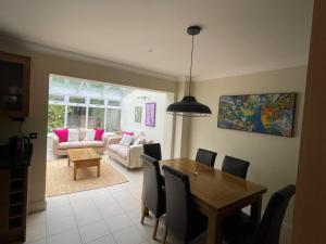 a dining room with a table and a couch at Henley - Luxurious Spacious Four Bedroom Two Bath in Henley on Thames