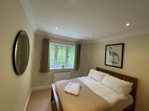 a bedroom with a bed with a towel on it at Henley - Luxurious Spacious Four Bedroom Two Bath in Henley on Thames