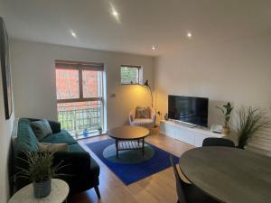 MAIDENHEAD Stylish and modern 2 bedroom apartment في ميدينهيد: غرفة معيشة مع أريكة وطاولة