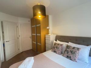 um quarto com uma cama com uma luz sobre ela em MAIDENHEAD Stylish and modern 2 bedroom apartment em Maidenhead