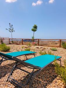 Tropical Dreams Motril في Los Tablones: نطيطين مع سجادات زرقاء على الشاطئ