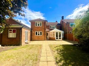 a brick house with a driveway in front of it at Chertsey Luxurious Three Bedroom Two Bath Home 3 in Chertsey