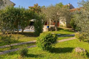 un jardin avec des arbres et de la pelouse ainsi qu'une maison dans l'établissement Villa DiVino by IstriaLux, à Bičići