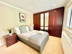 1 dormitorio con 1 cama y armario de madera en Chertsey Luxurious Three Bedroom Two Bath Home 3, en Chertsey