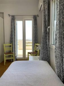 a bedroom with a bed and a window with chairs at Villa Blue in Agios Georgios +18 photos