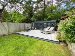 a backyard with a bench and a fence at Ascot stunning and modern 4 bedroom town house with 156 sq ft garden office 28 in Ascot