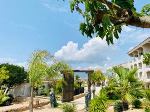 a garden with two statues of cats in front of a building at Bella Vista Hôtel, Suites & Maisons in Porticcio