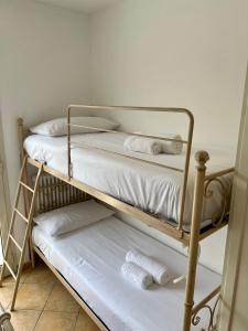 two bunk beds with white sheets and towels on them at Casa Anselmo in Loano