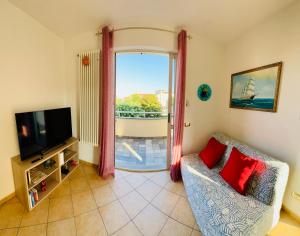 a living room with a couch and a tv and a window at Casa Anselmo in Loano