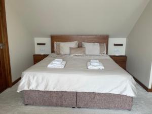 a bedroom with a large bed with towels on it at Waterfront House in Finstown
