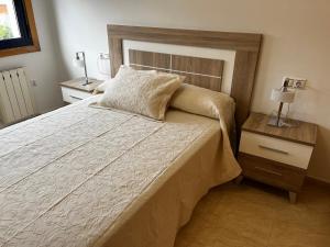 a bedroom with a large bed and a nightstand with a bed sidx sidx sidx at Apartamento en Boiro in Escarabote