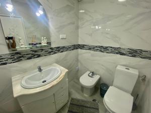 ein weißes Bad mit einem Waschbecken und einem WC in der Unterkunft casa hilario in Nazaré